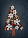 Gingerbread, nuts, spices, dried orange peel create a Christmas tree on a dark stone background Royalty Free Stock Photo