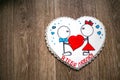 Gingerbread in the shape of a heart with a girl in a red skirt with a bow and a boy with a blue butterfly, holding a large heart. Royalty Free Stock Photo