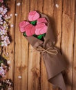 Gingerbread in the shape of roses in kraft paper on a wooden background