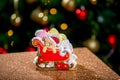 Gingerbread sleigh with teddy bear in front of defocused lights of Chrismtas decorated fir tree. Holiday sweets. New Year and Chri