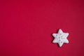 Gingerbread star with white icing and sprinkles on red background Royalty Free Stock Photo