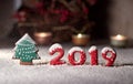On a gingerbread tree and numbers 2019 gingerbread snow falls. Christmas arrangement on the table Royalty Free Stock Photo