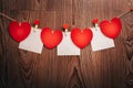 Gingham Love Valentine`s hearts natural cord and red clips hanging on rustic driftwood texture background Royalty Free Stock Photo