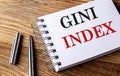 GINI INDEX text on notebook with pen on the wooden background Royalty Free Stock Photo