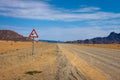 Giraffes crossing warning road sign placed in the desert of Namibia Royalty Free Stock Photo