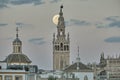 Giralda de Sevilla at night with big moon.