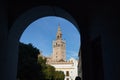 Giralda of Seville seen from the arch of the passageway leading to the Santa Cruz neighborhood. Concept travel, monuments, Royalty Free Stock Photo