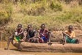 Giriama boys sitting on dugout canoe