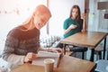 Girl absorbed in reading book during the break in cafe. Cute lovely young woman reading book and drinking coffee Royalty Free Stock Photo