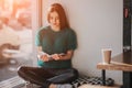 Girl absorbed in reading book during the break in cafe. Cute lovely young woman reading book and drinking coffee Royalty Free Stock Photo