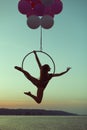 Girl acrobat hovers in the air on the balloons. Royalty Free Stock Photo