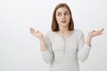Girl acting clueless in front of parents. Portrait of cute emotive european female brunette shrugging with hands spread