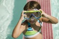 Girl (7-9) Adjusting Goggles in swimming pool portrait. Royalty Free Stock Photo