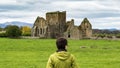 Girl admiring the ruins of a castle situated near a lake in Ireland highlands Royalty Free Stock Photo