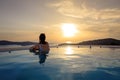 Girl admiring sunset from the pool. Summer vacation holiday