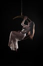 The girl, an aerial acrobat, performs on a sports equipment of the