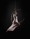 The girl, an aerial acrobat, performs on a sports equipment of the