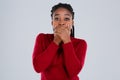 A girl, Afro-American,with her eyes frightened, covered her mouth with her hands.