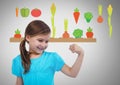 Girl against grey background with flexing arm muscles and vegetables