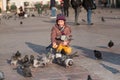 Girl age 6-8 years feeding pigeons at main square in old city Royalty Free Stock Photo