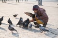 Girl age 6-8 years feeding pigeons at main square in old city Royalty Free Stock Photo