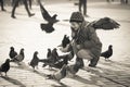 Girl age 6-8 years feeding pigeons at main square in old city Royalty Free Stock Photo