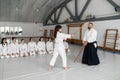 Girl and aikido master fighting with wooden sword during martial arts class Royalty Free Stock Photo