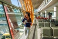 Girl at the airport window talking by phone. Royalty Free Stock Photo