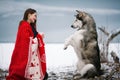 Girl with alaskan malamute dog wrapped in blanket and train dog