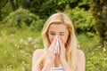 Girl with alergy blowing her nose.