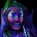 The girl aliens asleep. shrugs her shoulders, ultraviolet make-up.  She holds her hands near her face Royalty Free Stock Photo