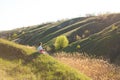 A girl alone enjoys the silence and beauty of nature, sitting on a hill in a picturesque place