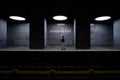 A girl alone in the light of ceiling lamps at an empty subway station