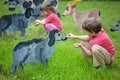 The girl anf the boy feed wooden sheeps Royalty Free Stock Photo