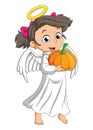 The girl with the angel costume is holding the pumpkin Royalty Free Stock Photo