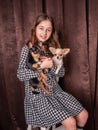 A teenage girl with two black and white mini chihuahua dogs in her arms. Girl and animals