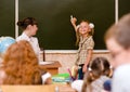 Girl answers questions of teachers near a school board Royalty Free Stock Photo