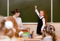 Girl answers questions of teachers near a school board Royalty Free Stock Photo