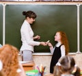 Girl answers questions of teachers near a school board Royalty Free Stock Photo