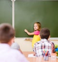 Girl answers questions of teachers near a school board Royalty Free Stock Photo