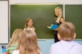 Girl answers questions of teachers near a school board Royalty Free Stock Photo