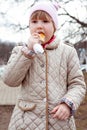 The girl with an appetite eats a loaf on the street