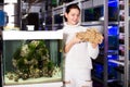 Girl in aquarium store holding big sandstone Royalty Free Stock Photo