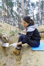 The girl-archaeologist cleans a wall excavation