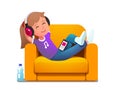 Girl in armchair enjoying music playing on phone