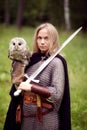 Girl in armor and with a sword holding an owl