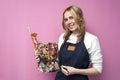 Girl artist holds brushes and a palette and smiles on a pink background, student of art school, profession of an artist