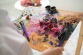 Girl artist mixes oil paints on a palette. Royalty Free Stock Photo
