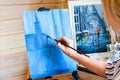 Girl artist paints a picture on canvas at home with oil paints at home. Royalty Free Stock Photo