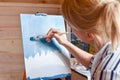 Girl artist paints a picture on canvas at home with oil paints at home. Royalty Free Stock Photo